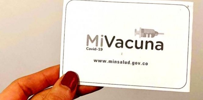 Foto de una mano sosteniendo el carné de vacunación ¡Recuerda! Desde hoy se pedirá carné de vacunación para aforos del 100%